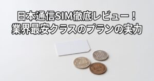 日本通信SIM徹底レビューのアイキャッチ、無地の背景にSIMカードと小銭を配置したミニマルな構図